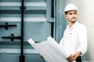 Civil engineer holding blueprint at the construction site.